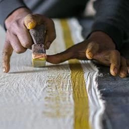 Artisan performing traditional block printing process on fabric at Chandra Textiles Hub